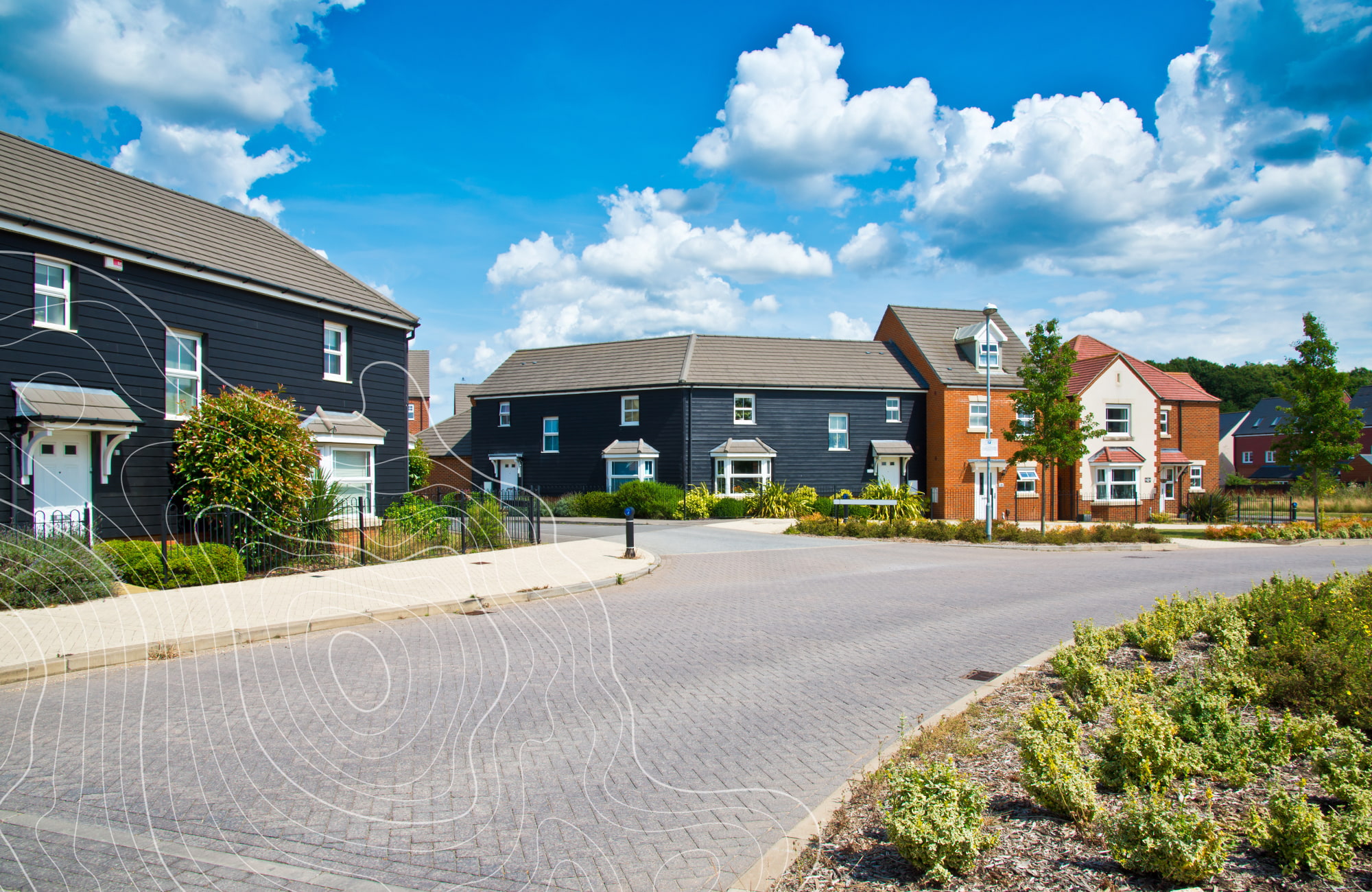 UK street of newly built houses on housing estate with blue sky