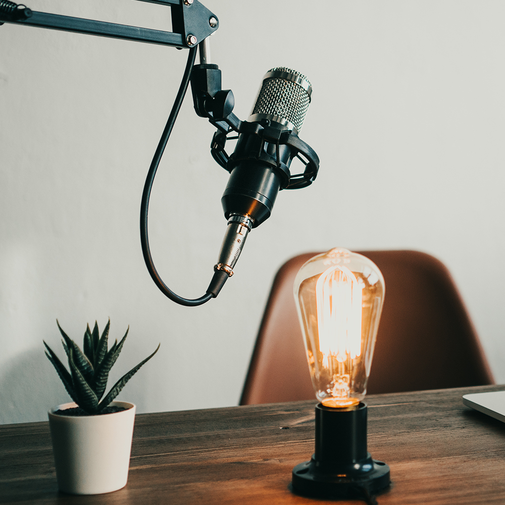 Podcast recording with a microphone and lightbulb on table